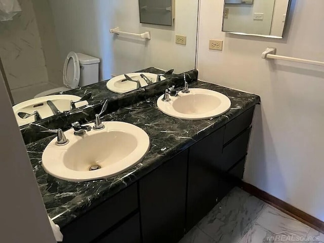 bathroom featuring marble finish floor, a sink, and baseboards