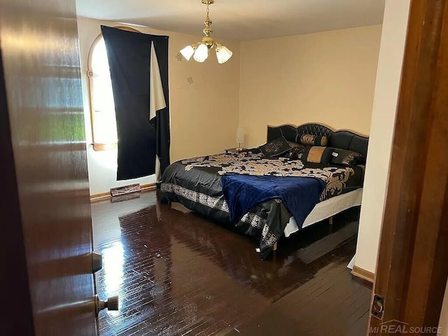 bedroom with wood-type flooring, baseboards, and a chandelier