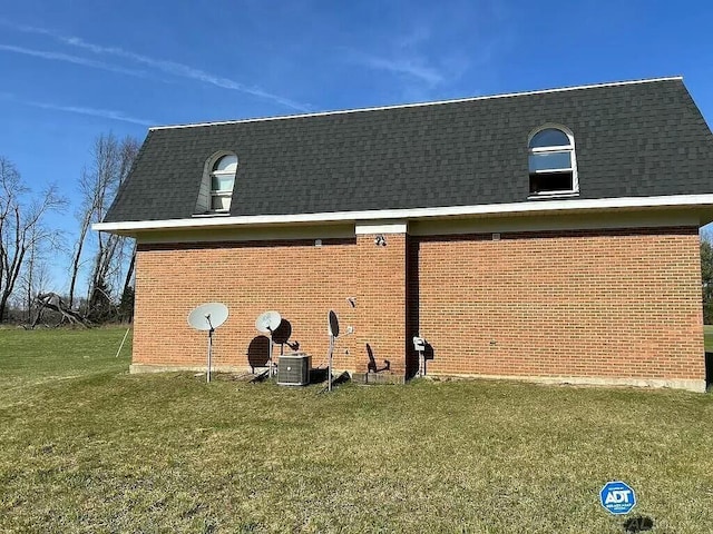 exterior details featuring central air condition unit, roof with shingles, and brick siding