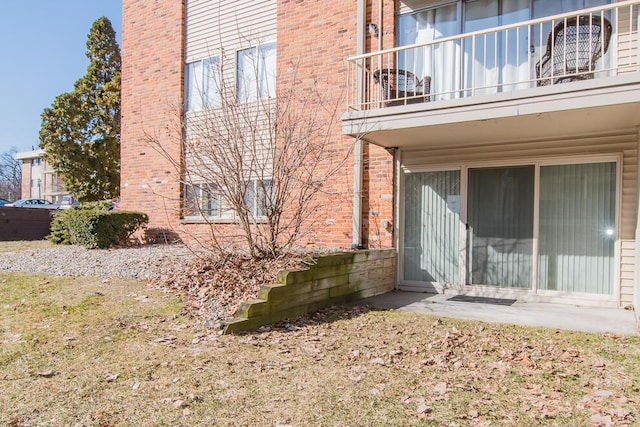 back of property with brick siding and a balcony