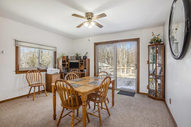 dining space featuring light carpet, baseboards, and a wealth of natural light