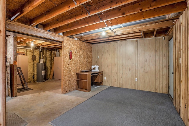 unfinished basement with water heater and wooden walls