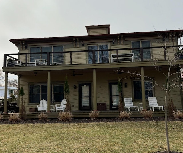 back of house featuring a yard, a balcony, covered porch, and a ceiling fan