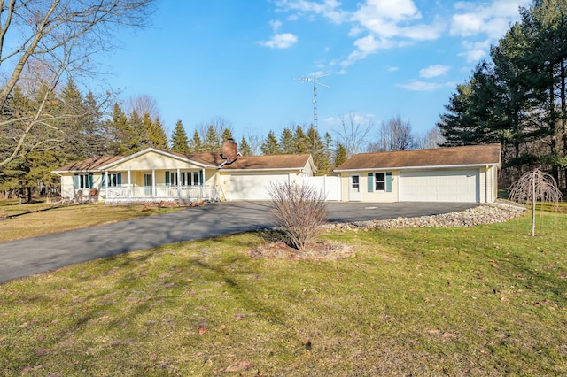 view of front of property featuring a garage, a chimney, fence, a porch, and a front yard