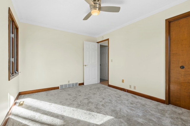 unfurnished bedroom with baseboards, carpet, visible vents, and crown molding