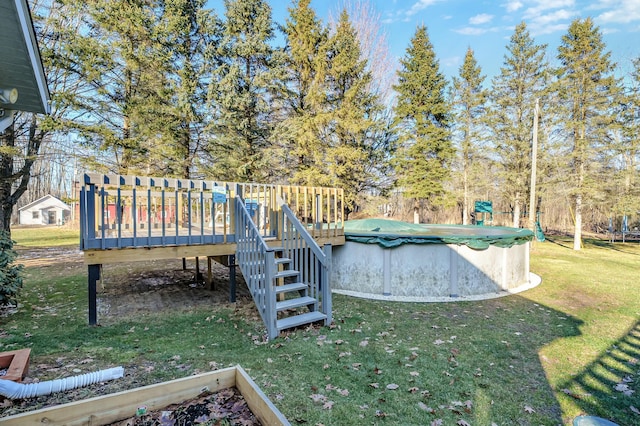 view of yard with a deck and a covered pool