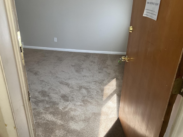 spare room featuring baseboards and carpet flooring