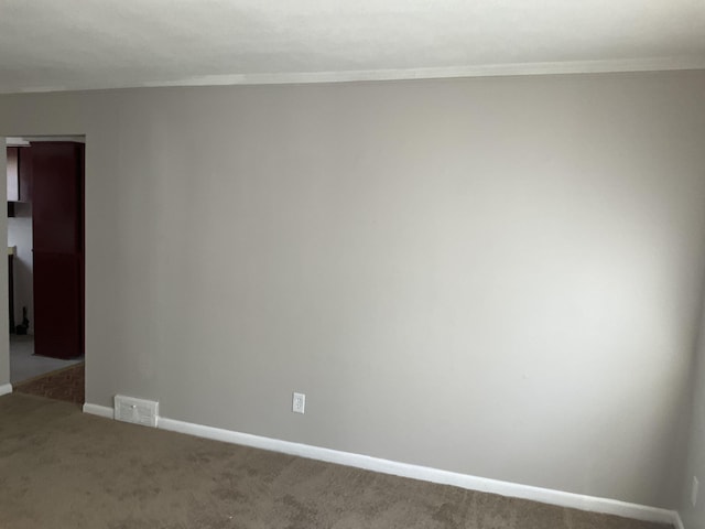 spare room featuring carpet floors, baseboards, and visible vents