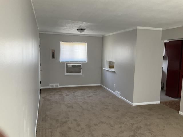 empty room with cooling unit, crown molding, visible vents, and carpet flooring