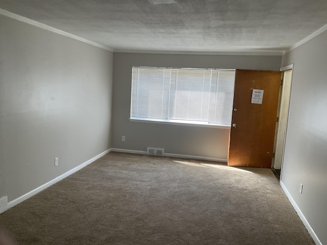 spare room with visible vents, carpet flooring, a textured ceiling, and ornamental molding