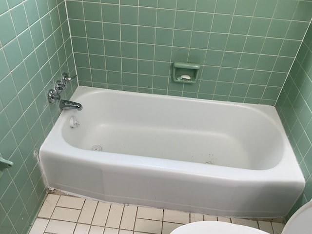 bathroom featuring a bathtub, toilet, and tile patterned floors