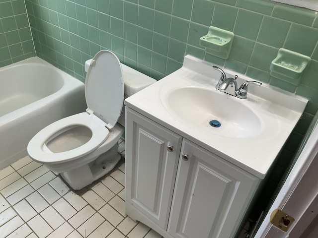 full bathroom with a tub to relax in, toilet, vanity, tile walls, and tasteful backsplash