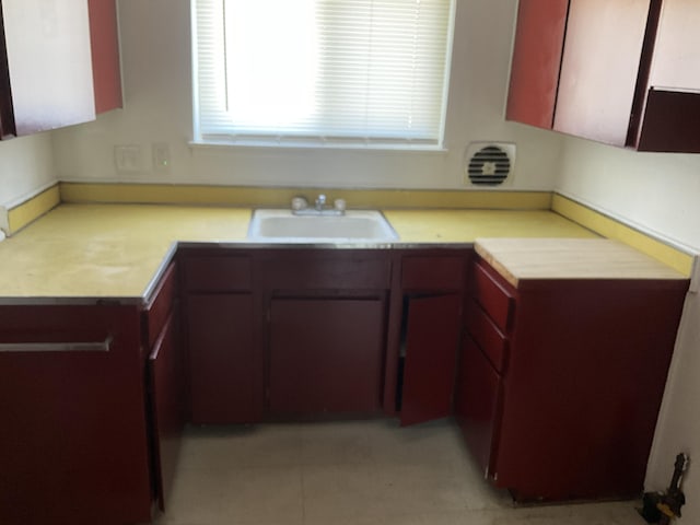 kitchen featuring light tile patterned floors, light countertops, and a sink