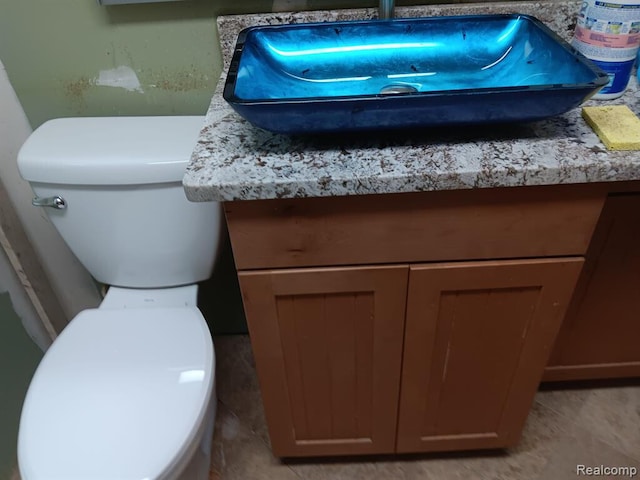 half bathroom with toilet and vanity