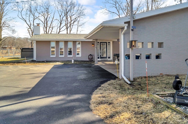 5007 S 42nd St, Climax, MI 49034 - view of property exterior featuring a chimney, driveway, brick siding, and fence
