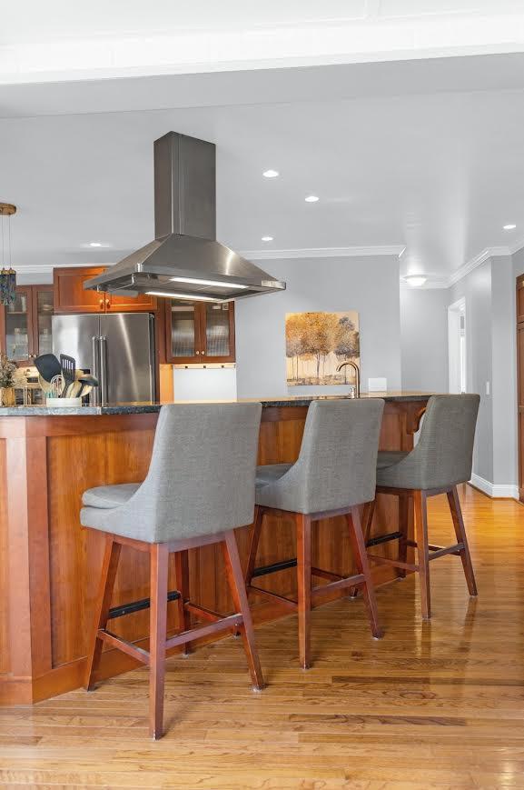 5007 S 42nd St, Climax, MI 49034 - kitchen featuring high end fridge, island range hood, ornamental molding, a breakfast bar area, and light wood-style floors