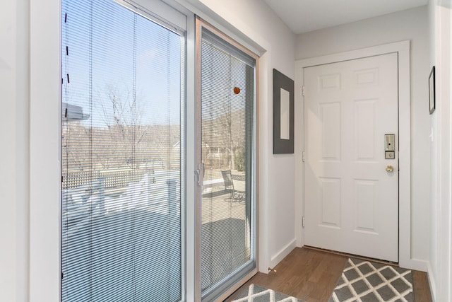 doorway featuring dark wood-type flooring and baseboards