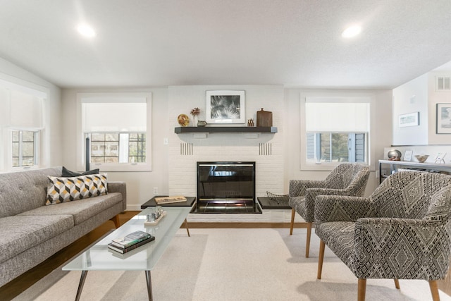 living room featuring visible vents, recessed lighting, a fireplace, and wood finished floors