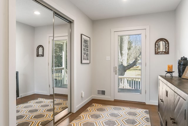 doorway to outside with recessed lighting, visible vents, baseboards, and dark wood-type flooring