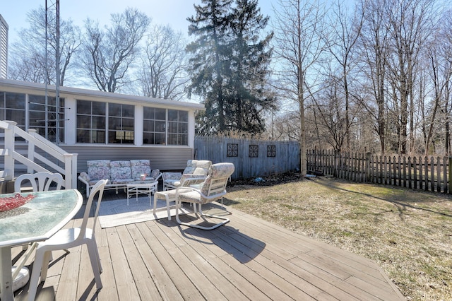 wooden terrace with an outdoor living space, fence, and a sunroom