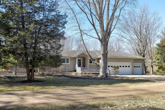 view of front facade featuring an attached garage, covered porch, and driveway