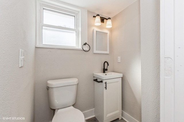 bathroom featuring a sink, toilet, and baseboards