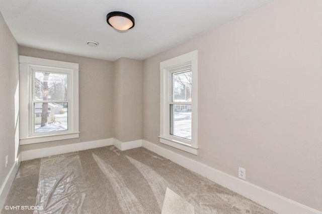 unfurnished room with carpet floors and baseboards