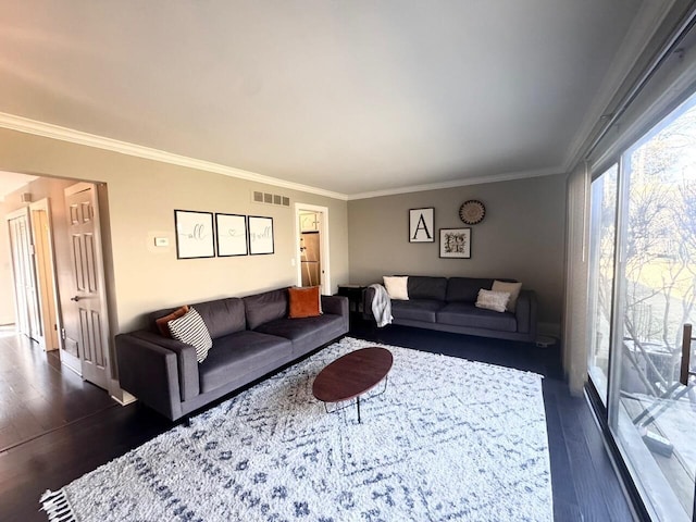 living room with dark wood-style flooring, visible vents, and crown molding