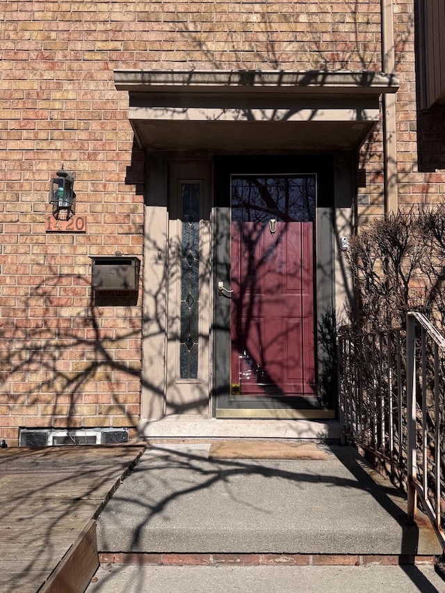 doorway to property featuring brick siding