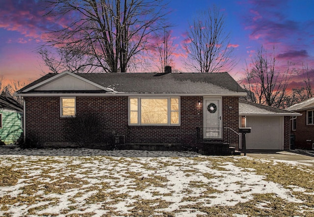 view of front of home featuring a garage, brick siding, and driveway