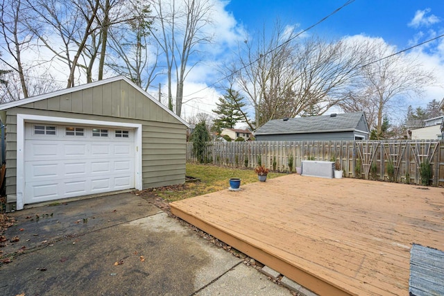 detached garage featuring driveway and fence