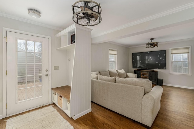 living room featuring ornamental molding, baseboards, and wood finished floors