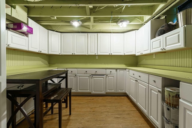 kitchen with light countertops, white cabinetry, and light wood finished floors