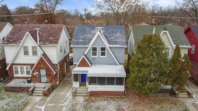 view of front facade with a shingled roof and brick siding