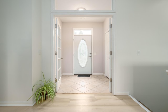 entryway with light tile patterned floors and baseboards