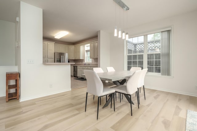 dining room with light wood-style floors and baseboards