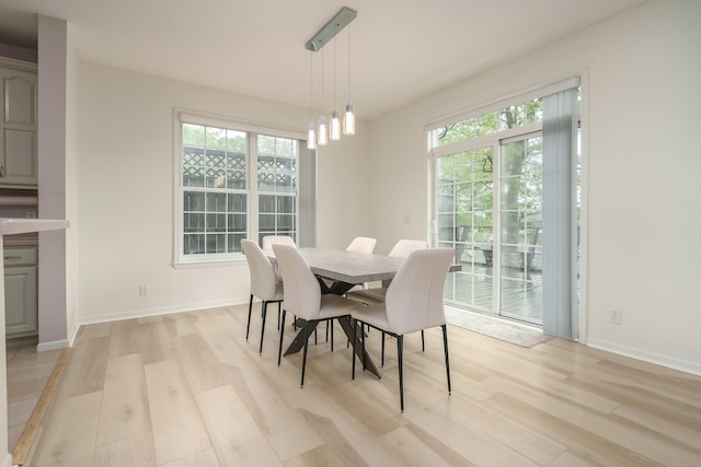 dining area with light wood-type flooring and baseboards