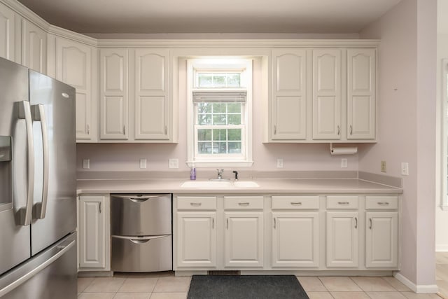 kitchen featuring light countertops, appliances with stainless steel finishes, light tile patterned flooring, and a sink