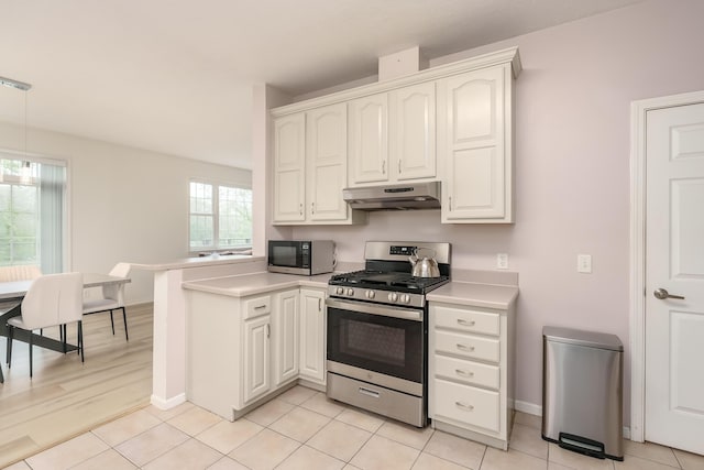 kitchen featuring light tile patterned floors, appliances with stainless steel finishes, a peninsula, light countertops, and under cabinet range hood