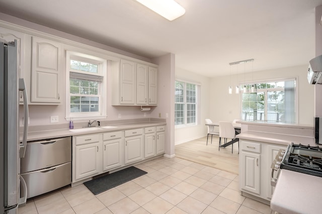 kitchen featuring stainless steel appliances, a healthy amount of sunlight, light countertops, and a sink