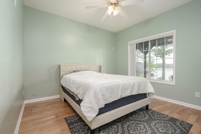 bedroom featuring baseboards, a ceiling fan, and light wood-style floors