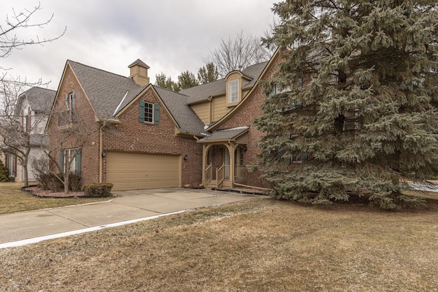 view of front facade featuring roof with shingles, an attached garage, a chimney, concrete driveway, and brick siding