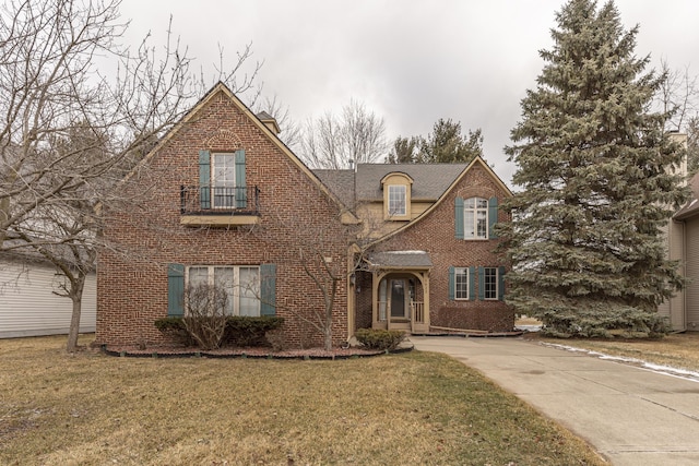 view of front facade featuring a front yard, concrete driveway, and brick siding