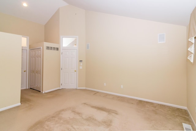 empty room featuring visible vents, vaulted ceiling, and carpet