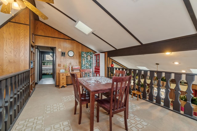 dining room with wooden walls, vaulted ceiling, and a ceiling fan