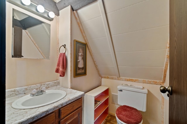 bathroom with lofted ceiling, vanity, and toilet