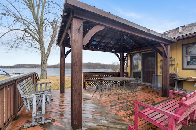 wooden deck featuring a water view, outdoor dining space, and a gazebo