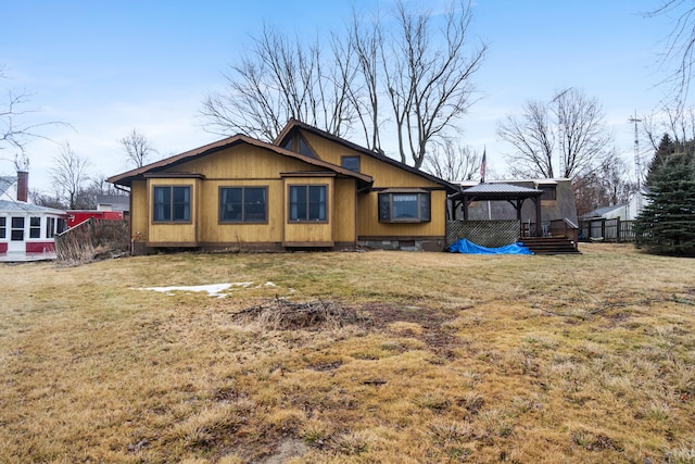 rear view of property with a yard and a gazebo