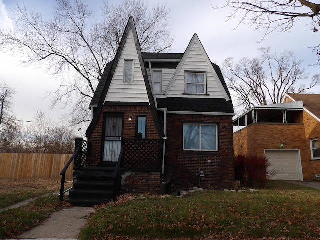 view of front of house with a shingled roof, fence, and brick siding