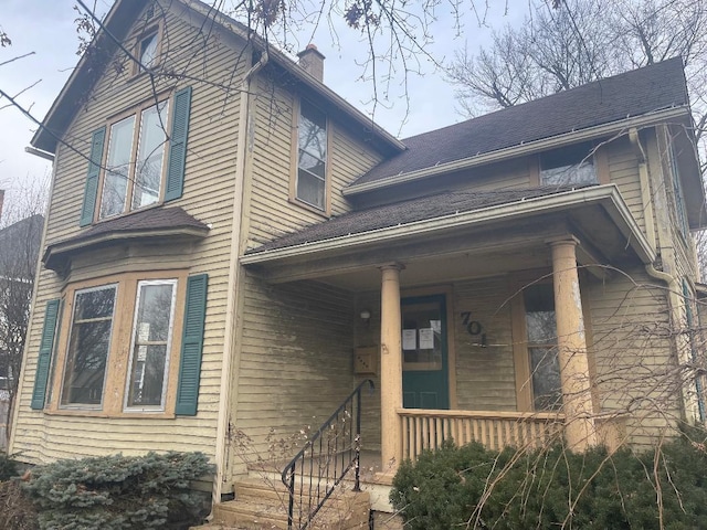 exterior space featuring covered porch and a chimney